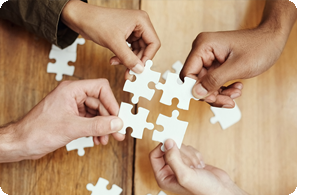 händer som håller i pusselbitar