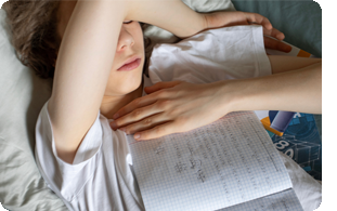 trött tonåring i sängen med läxor